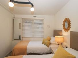 A bedroom with two beds and a lamp at Cosy Corner White Cross Bay near Troutbeck Bridge