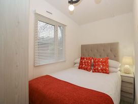 A bedroom with a bed and nightstand at Cosy Corner White Cross Bay near Troutbeck Bridge