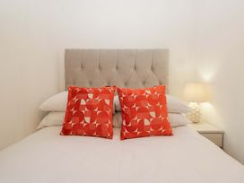 A bedroom with a bed and patterned pillows at Cosy Corner White Cross Bay near Troutbeck Bridge