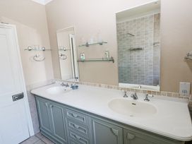 A bathroom with a double sink vanity and large mirrors at Hereford House in Tenby