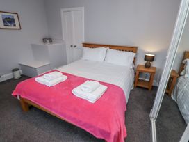 A bedroom with a bed and towels at Kennie Cottage in Seahouses