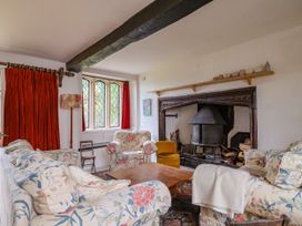 A living room with a fireplace and seating at Hole House in Branscombe