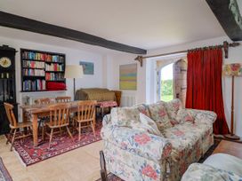 A living room with a dining table and sofa at Hole House in Branscombe