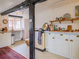 A kitchen with an oven and shelves at Hole House in Branscombe