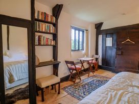 A bedroom with a bed and bookshelf at Hole House in Branscombe