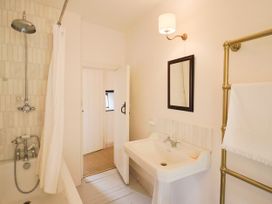 A bathroom with a bathtub and washbasin at Hole House in Branscombe