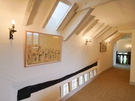A corridor with artwork and light fixtures at Hole House in Branscombe