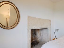 A bedroom with a mirror and fireplace at Hole House in Branscombe