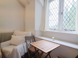 A sitting room with an armchair and wooden table at Hole House in Branscombe