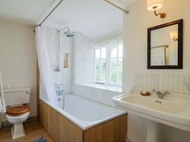 A bathroom with a bathtub, toilet, and sink at Hole House Branscombe