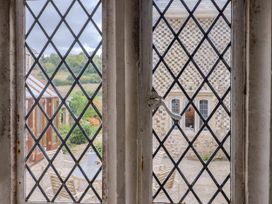 A view through a window showing an outdoor seating area at Hole House in Branscombe