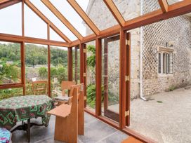A conservatory with a table and chairs at Hole House in Branscombe