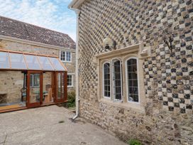 An outdoor view of a stone wall and conservatory at Hole House in Branscombe