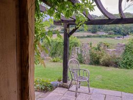 An outdoor area with a chair and plants at Hole House in Branscombe