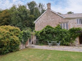 A garden with a table and chairs at Hole House in Branscombe