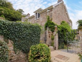 A garden entrance with gate and greenery at Hole House in Branscombe