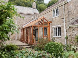 A conservatory attached to a stone house at Hole House in Branscombe
