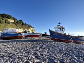 Boats on a pebbly beach with cliffs in the background at Hole House in Branscombe