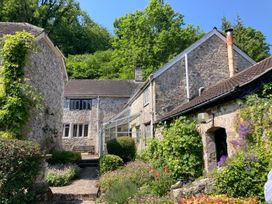 An outdoor area with stone houses and a glass conservatory at Hole House in Branscombe