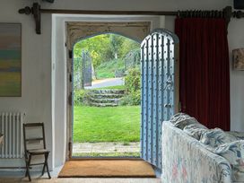 An entrance view with an open door leading to a garden at Hole House in Branscombe