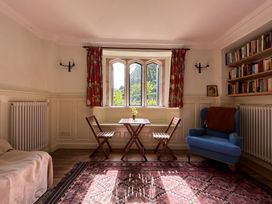 A sitting room with chairs and a table at Hole House in Branscombe