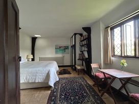 A bedroom with a bed and a small dining area at Hole House in Branscombe
