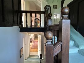 A hallway with a staircase and a doorway at Hole House in Branscombe