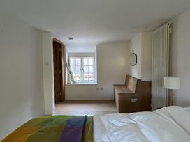A bedroom with a bed, a window, and a bench at Hole House Branscombe