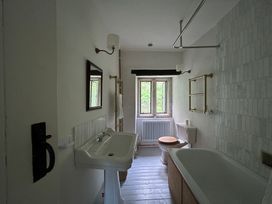 A bathroom with a sink, toilet, and bathtub at Hole House in Branscombe