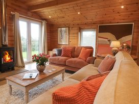A living room with sofas cushions a coffee table with flowers a fireplace and wall art at Artisan Lodge in Longridge