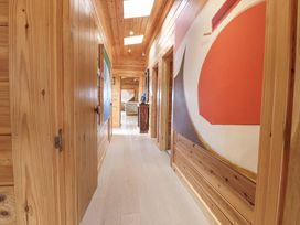 A wooden hallway with abstract paintings on the walls and skylights at Artisan Lodge in Longridge