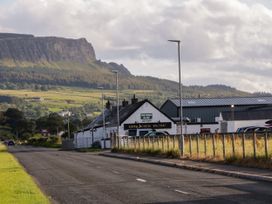 A roadside building with a sign for anglers rest and cars parked nearby against a background of hills and fields at Meric Stone Holiday lets Caravan 1 in Benone near Castlerock