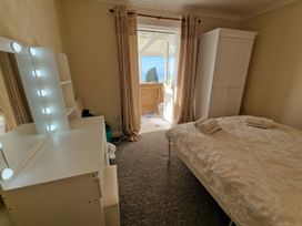 A bedroom with a bed and a dressing table at Woodland Roost in Barmouth