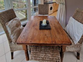 A dining room with a wooden table and chairs at Woodland Roost in Barmouth