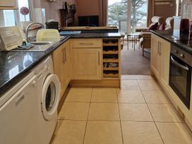 A kitchen with washing machine and sink at Woodland Roost in Barmouth