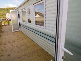 A wooden deck outside a caravan with an open door at Meric Stone Holiday Lets Caravan 2 Benone near Castlerock