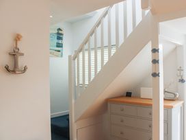 A hallway with a staircase and a chest of drawers at Old Police House Salcombe