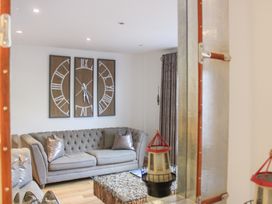 A living room with a sofa and decorative clock at Old Police House in Salcombe