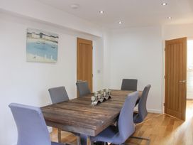 A dining room with a wooden table and chairs at The Old Police House in Salcombe