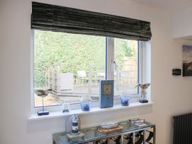 A living room with a window displaying decorative items at Old Police House in Salcombe