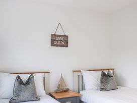 A bedroom with two beds and a wooden sign at Old Police House Salcombe