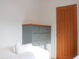 A bedroom with a bed and a drawer unit at Old Police House, Salcombe