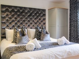 A bedroom with a bed and storage cabinet at Old Police House Salcombe