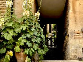 A pathway with flowers beside a gate at Lamorna Cottage Chipping Norton