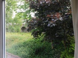 A view of green bushes and trees outside a window at New Tower House- 10 Pear Tree Court in York