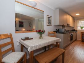 A kitchen with wooden table and chairs a countertop with appliances and cabinets at New Tower House 10 Pear Tree Court York