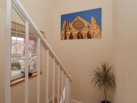 A stairway with white railing a window with flowers and a wall photo above a plant at New Tower House- 10 Pear Tree Court in York