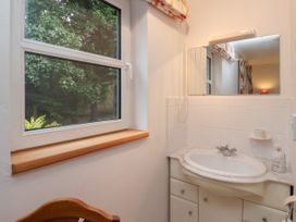 A bathroom sink with a mirror above it and a window showing trees at New Tower House- 10 Pear Tree Court in York