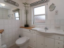 A bathroom with a toilet sink cabinets window and a plant on the counter at New Tower House- 10 Pear Tree Court in York