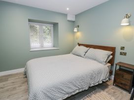 A bedroom with a bed and nightstand at Frongoch Old Power House in Dolgellau
